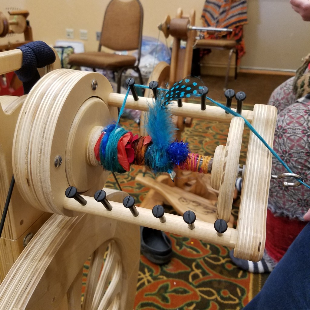 Feather and pompoms in yarn