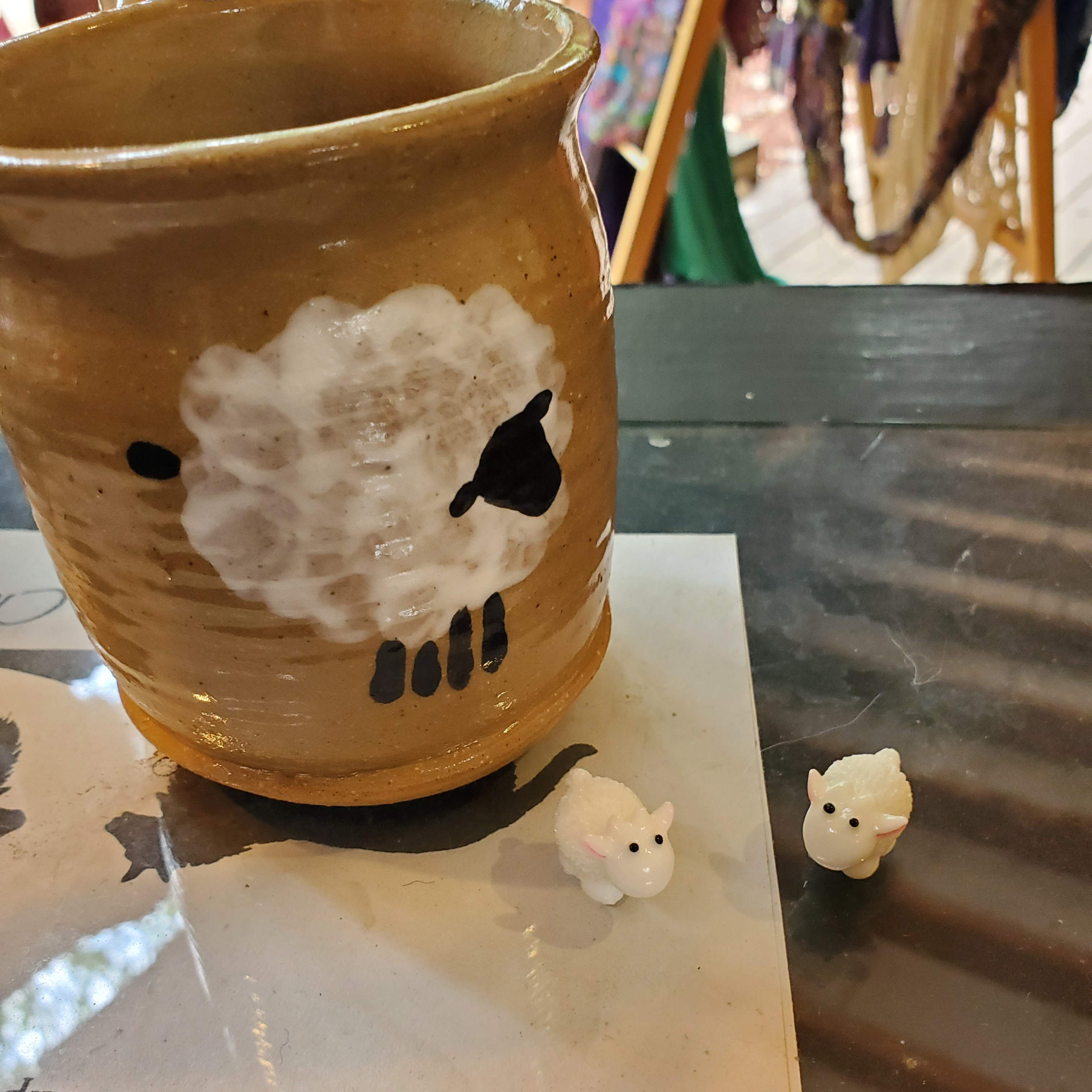 tiny glass sheep next to a sheep mug