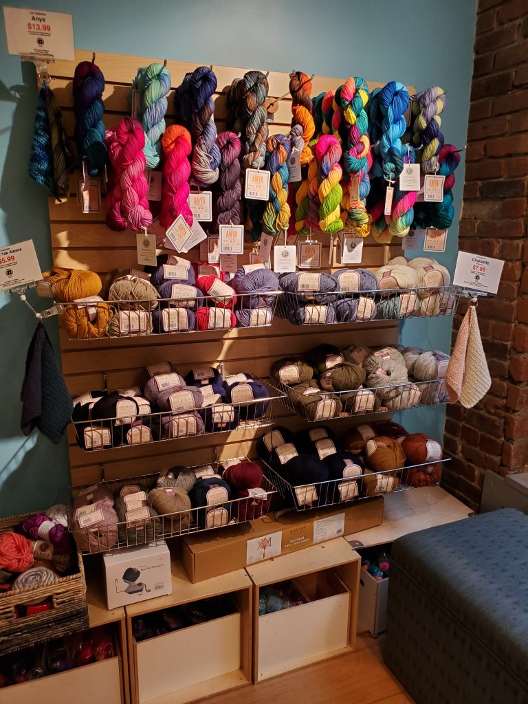Wall of sale yarns in the Lion Brand Studio