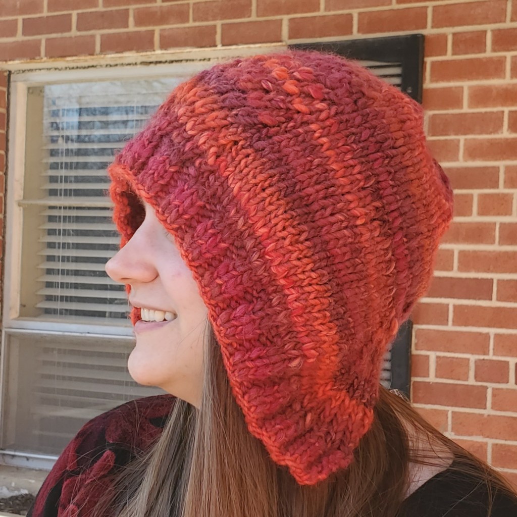 Emma modeling the red She's a Betty Bonnet with the brim rolled down