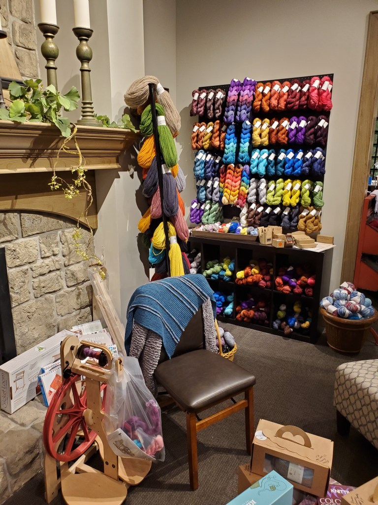 A wall of yarn and a spinning wheel