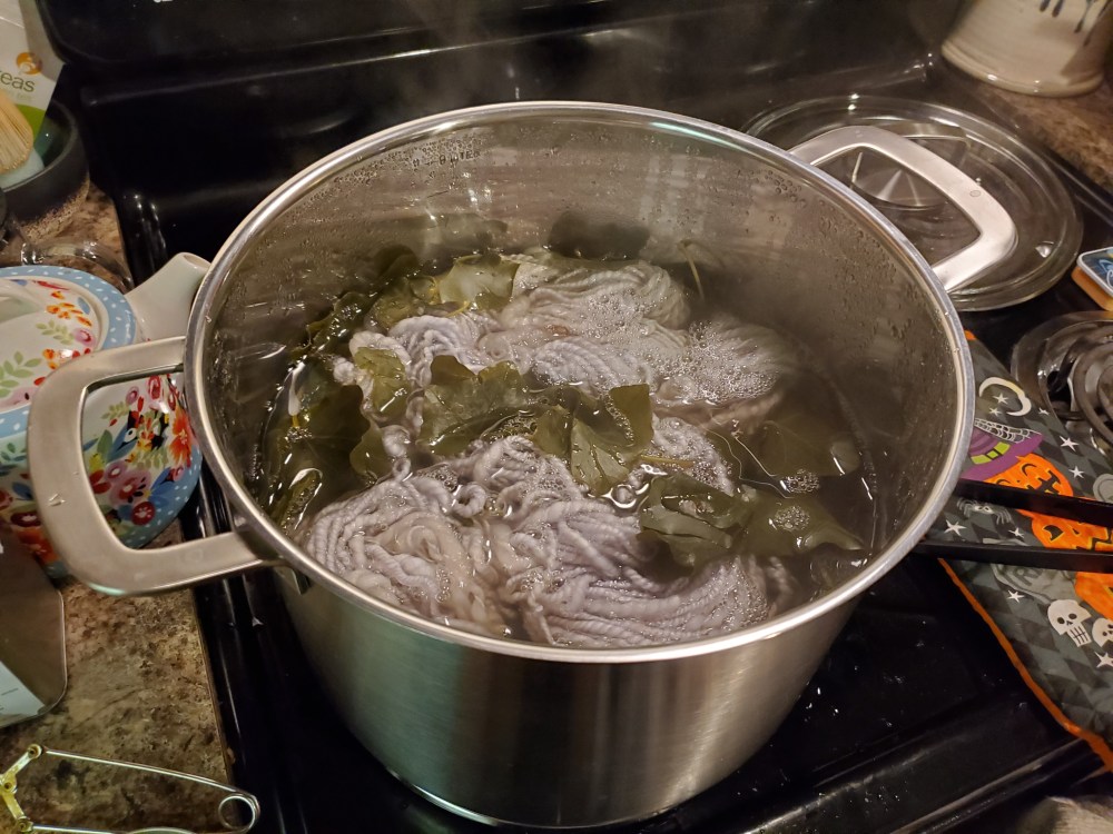 Dye pot full of ivy leaves and yarn