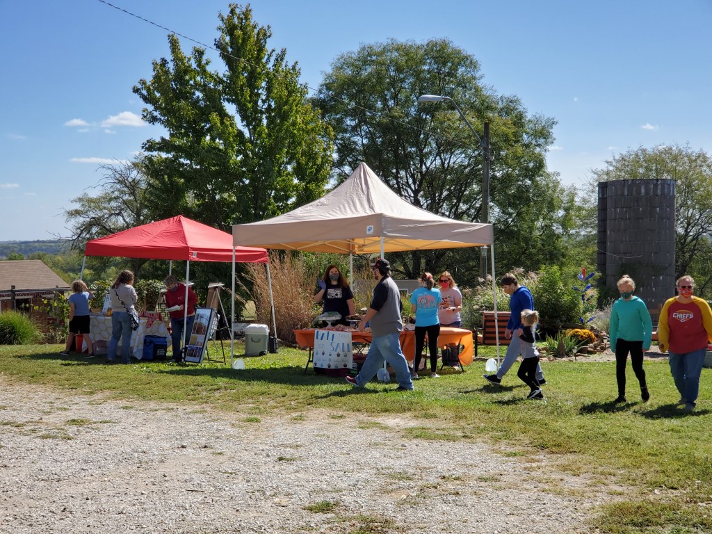 Farm tents with masked folks