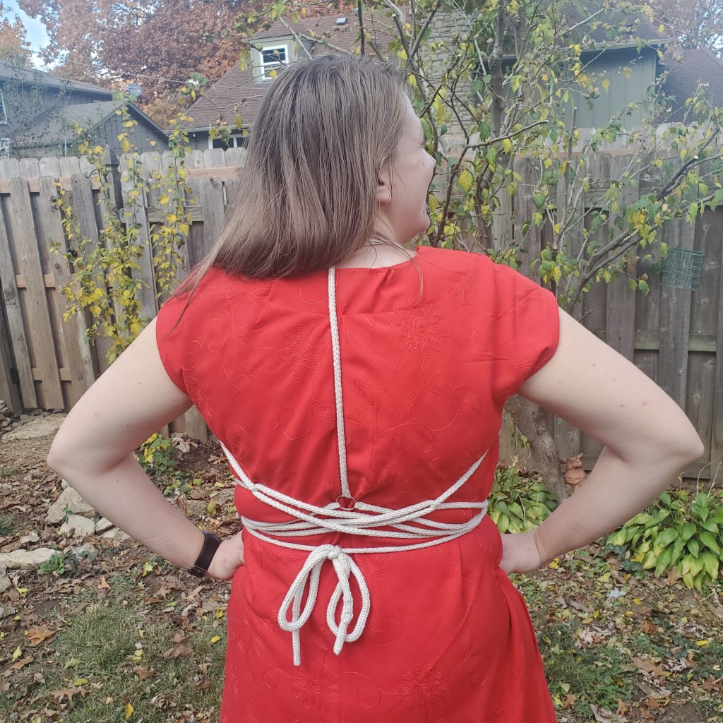 Back of Emma in dress and harness