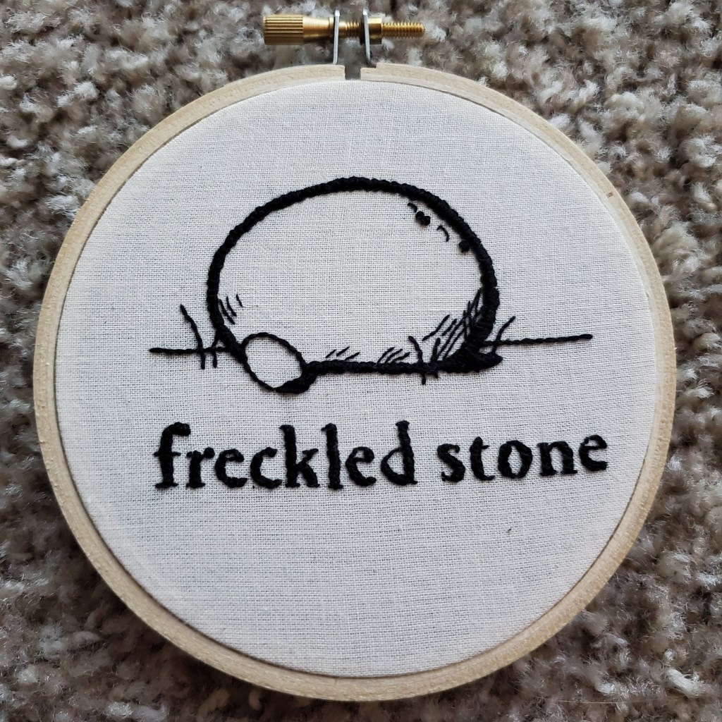 Hoop that has an image of a rock and text that reads "freckled stone"
