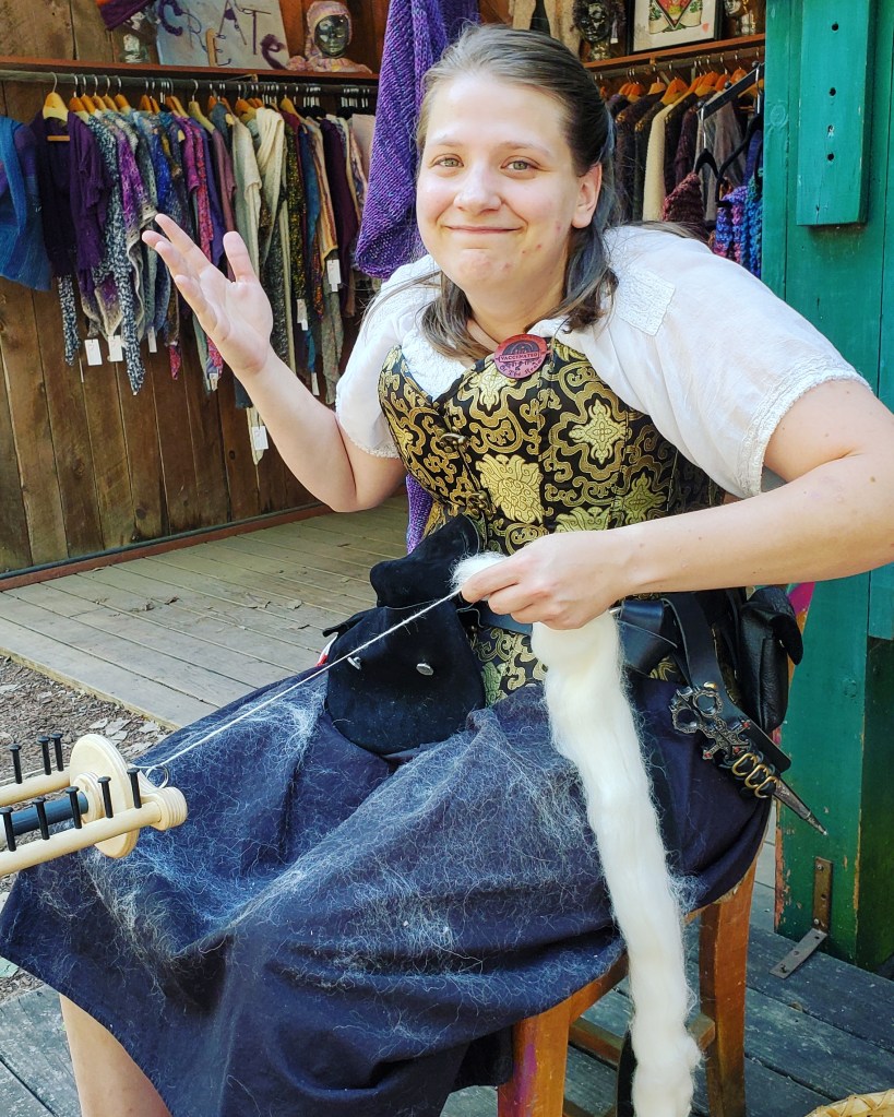 Emma spinning with fiber stuck all over her skirt