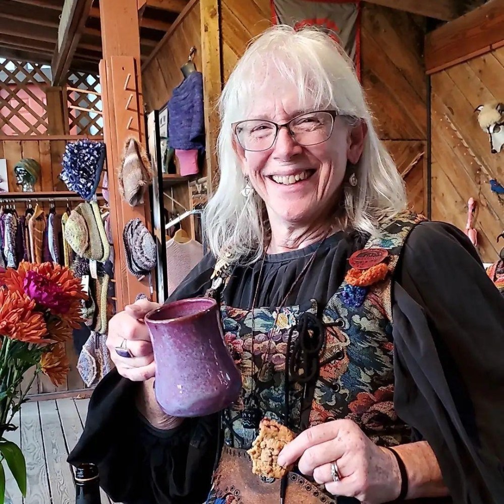 Marci holding a mug and a cookie