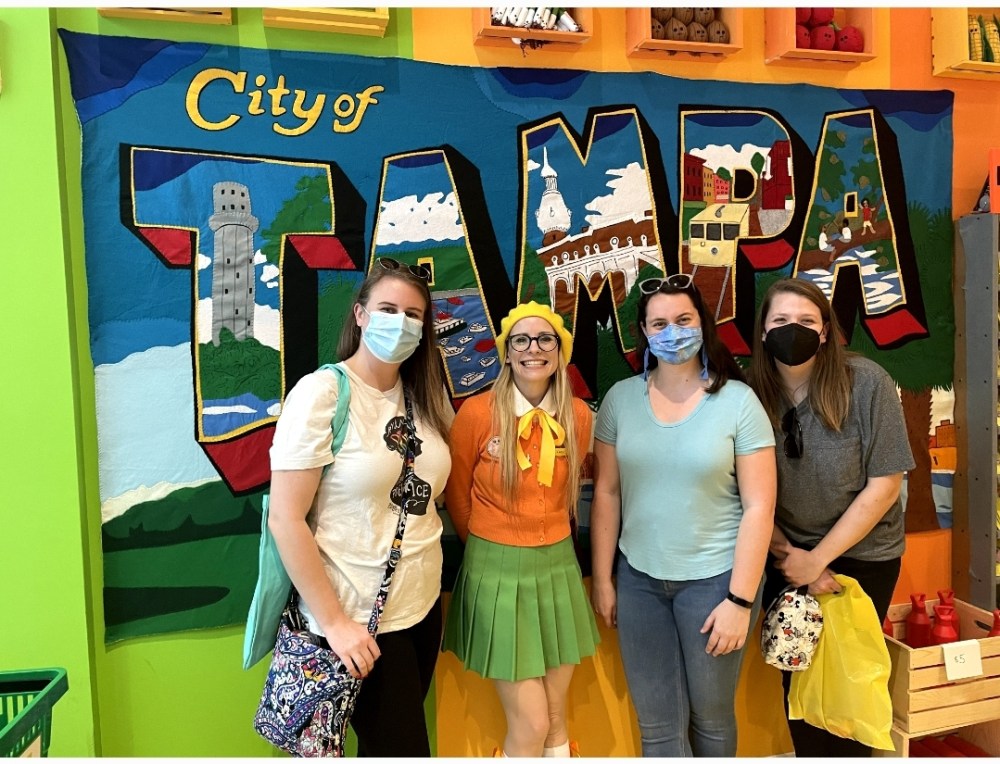 Liz, Lucy, Lauren, and Emma in front of a felt mural