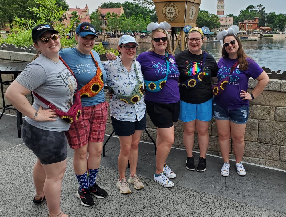 Six people wearing sunflower crossbody bags
