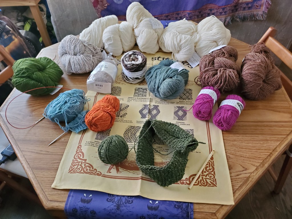 A table full of yarn and started knitting projects from Ireland